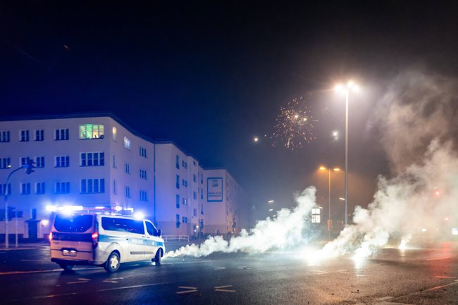 Polizeiwagen vor rauchender Pyrotechnik in der Nacht Polizeiwagen vor rauchender Pyrotechnik in der Nacht
