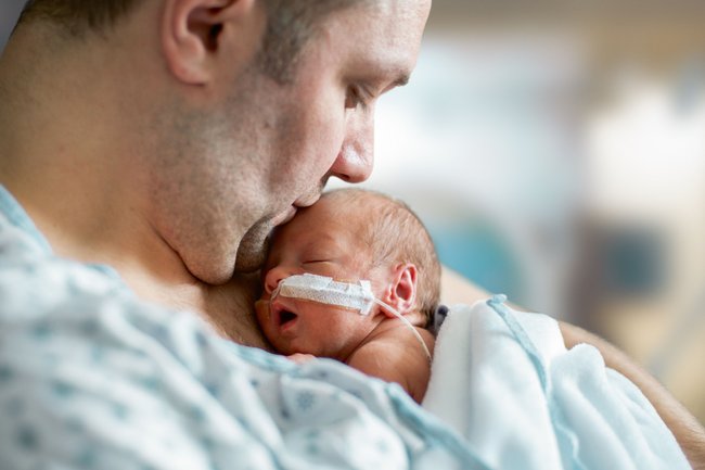 Ein Frühchen im Arm seines Vaters