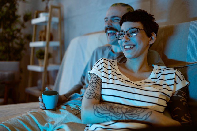 Pärchen sitzt lachend vor dem Fernseher. Pärchen sitzt lachend vor dem Fernseher.
