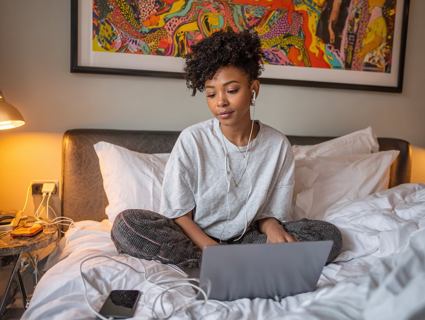 Gen Z Frau in ihrem Bett mit Laptop