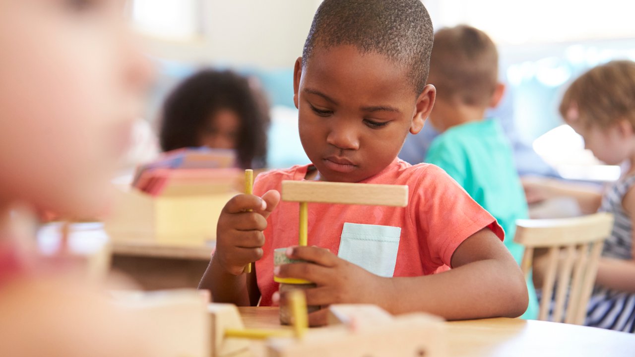 Montessori-Schule: Kind lernt mit Holzbausteinen