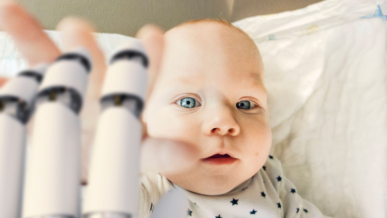Portrait of baby boy reaching for robot hand model