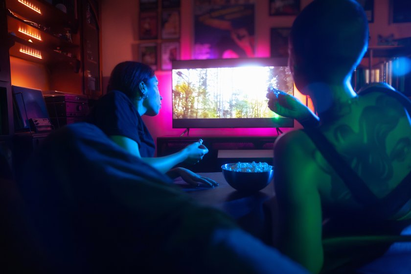 Zwei junge Frauen sitzen Popcorn essend vor dem Fernseher. Zwei junge Frauen sitzen Popcorn essend vor dem Fernseher.