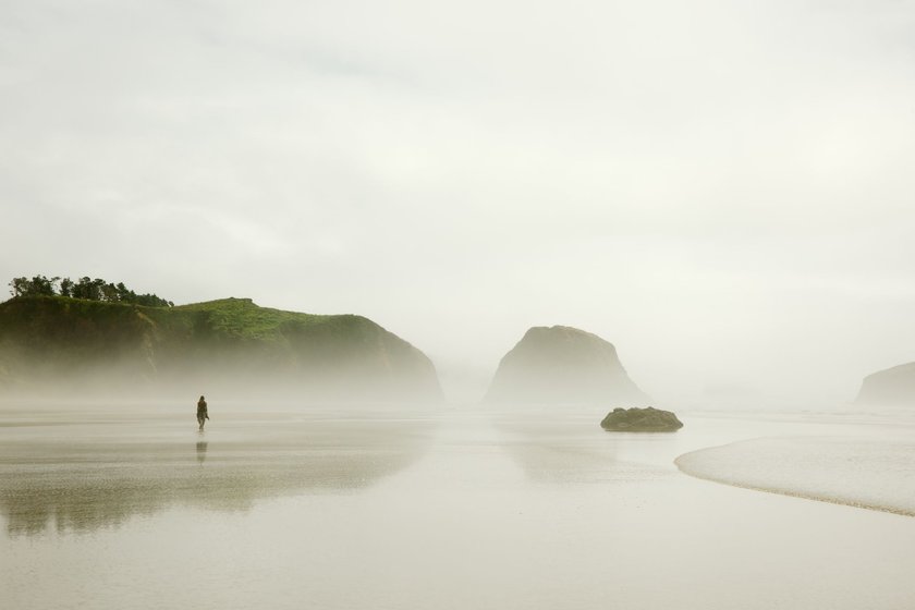 Eine Frau wandert allen durch eine nebelige Landschaft und der Himmel ist bewölkt. Eine Frau wandert allen durch eine nebelige Landschaft und der Himmel ist bewölkt.