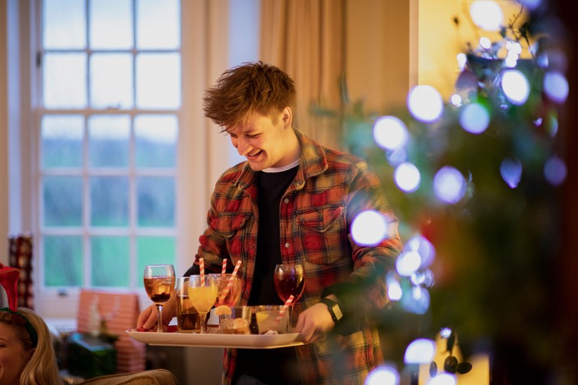 Junger Mann serviert seinen Gästen Drinks Junger Mann serviert seinen Gästen Drinks