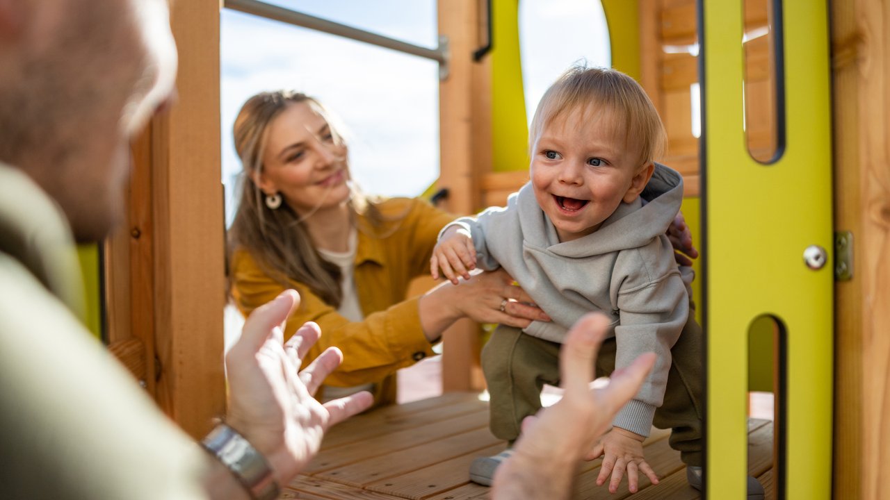 Candid snapshot of family happiness as parents bond with their toddler in an outdoor setting Candid snapshot of family happiness as parents bond with their toddler in an outdoor setting