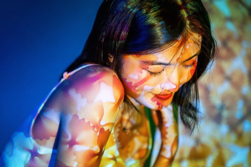 Frau wird von buntem Licht angestrahlt Frau wird von buntem Licht angestrahlt