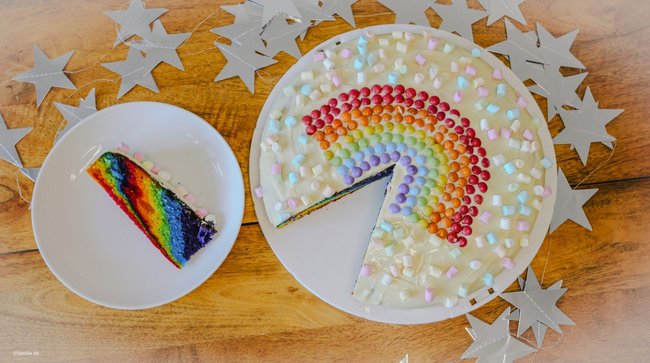 Regenbogenkuchen backen: Der mit einem bunten Smarties-Regenbogen verzierte Regenbogenkuchen sieht angeschnitten und ganz einfach toll aus.