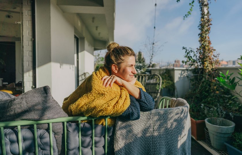 Junge Frau entspannt sich auf dem Balkon Junge Frau entspannt sich auf dem Balkon