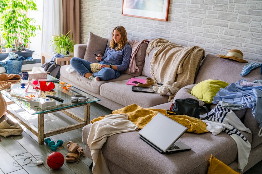Teenager sitzt in einem unordentlichen Zimmer vor dem Fernseher. Teenager sitzt in einem unordentlichen Zimmer vor dem Fernseher.