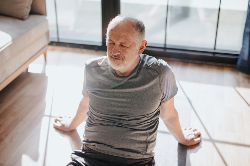 Anti-Stress-Tipps für Boomer: Mann sitzt entspannt auf dem Boden Anti-Stress-Tipps für Boomer: Mann sitzt entspannt auf dem Boden