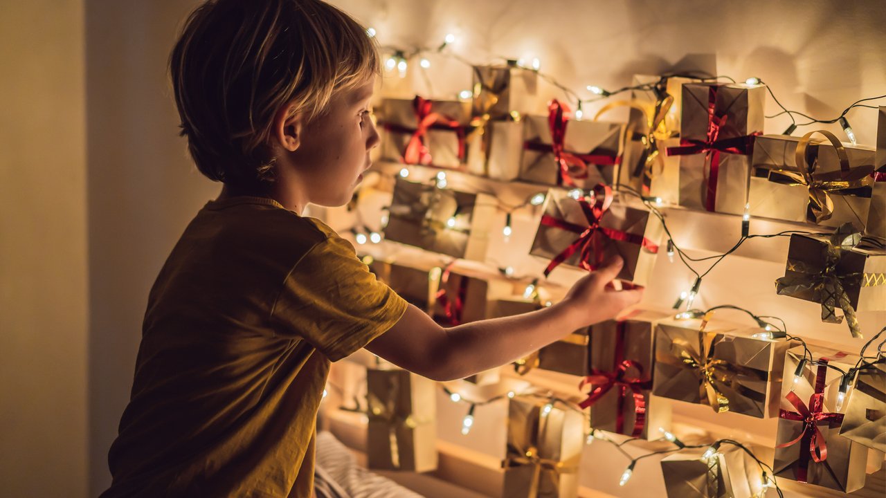 Adventskalender füllen für Kinder: Kind öffnet Weihnachtskalender