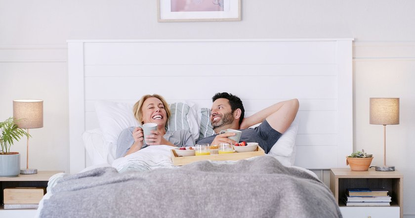 Paar verbringt während des Frühstücks gemeinsam Zeit im Bett Paar verbringt während des Frühstücks gemeinsam Zeit im Bett