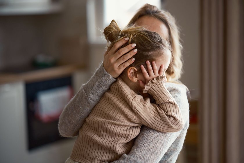 Resilienz still fördern: Mama hält trauriges Kind im Arm Resilienz still fördern: Mama hält trauriges Kind im Arm