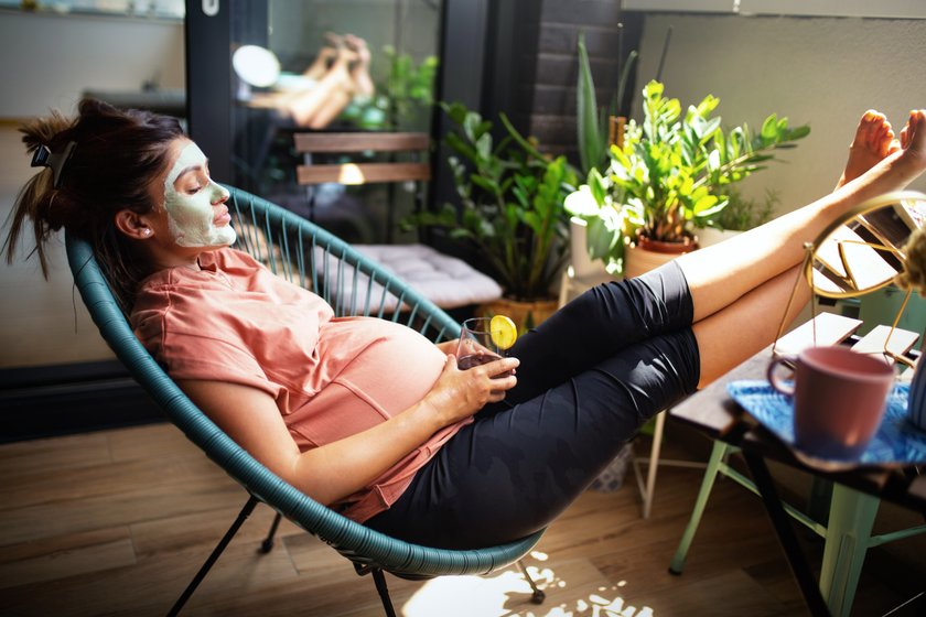 Schwangere Frau gönnt sich Ruhe und macht dabei eine Gesichtsmaske Schwangere Frau gönnt sich Ruhe und macht dabei eine Gesichtsmaske