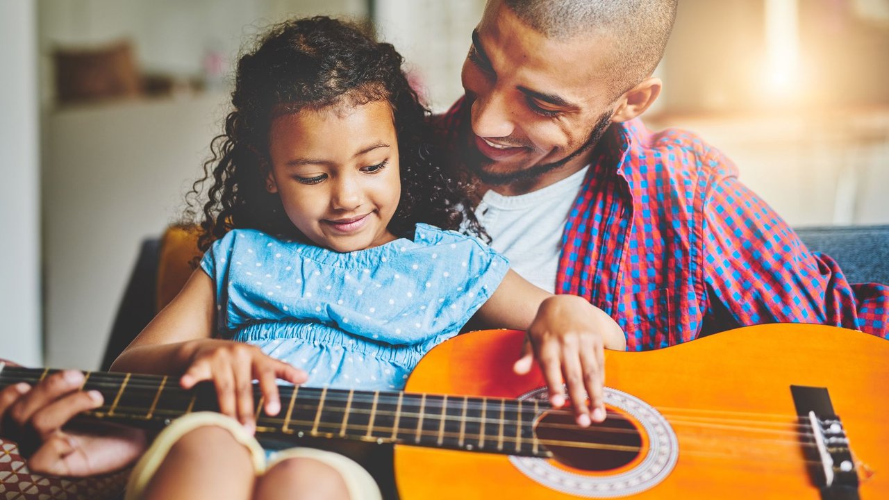 Fragen, die Kinder empowern: Papa und Tochter spielen Gitarre