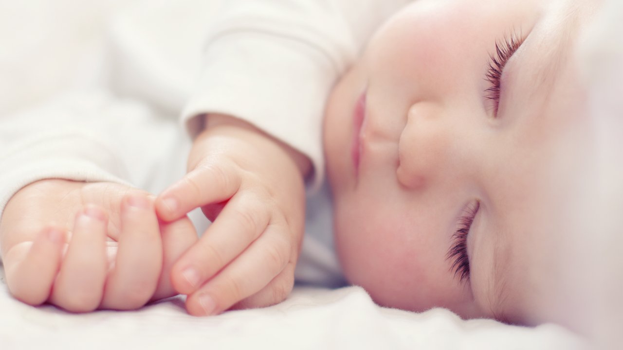 Schlafbedarf Baby: Baby schläft in Bettchen