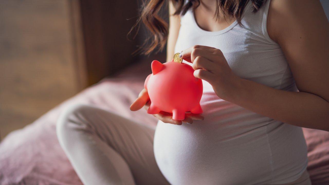 Baby-Gratis-Willkommenspaket: Schwangere Frau mit Sparschwein