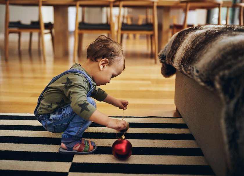 Montessori Kalender Weihnachten: Kleinkind spielt mit Weihnachstskugel