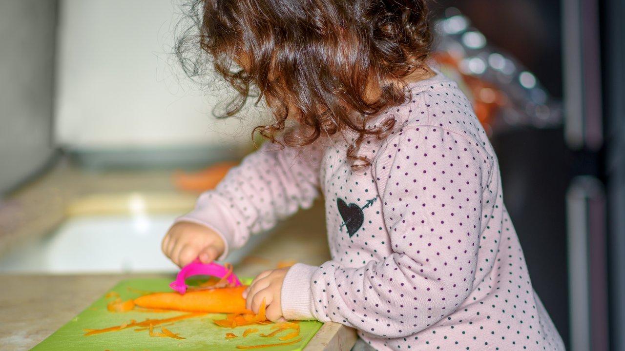 Montessori Küche einrichten: Kind schält Gemüse