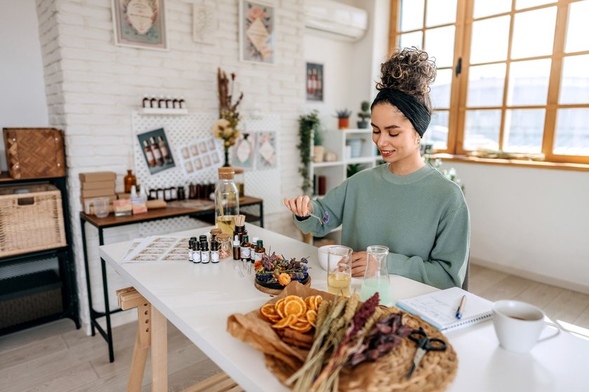 Smiling casually clothed beautiful woman developing her new organic products at her home based workshop Smiling casually clothed beautiful woman developing her new organic products at her home based workshop
