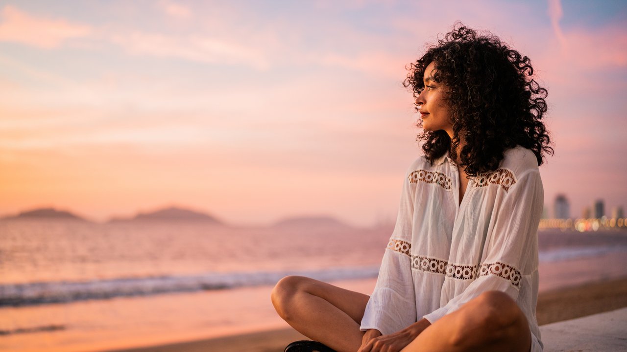 Wie leicht lässt du dich beeinflussen?: Frau sitzt nachdenklich am Strand Wie leicht lässt du dich beeinflussen?: Frau sitzt nachdenklich am Strand