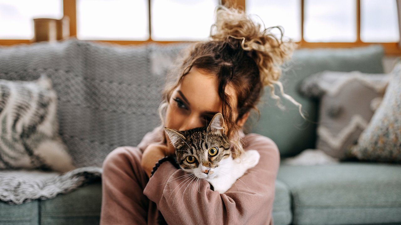 Young woman bonding with her cat in apartment
