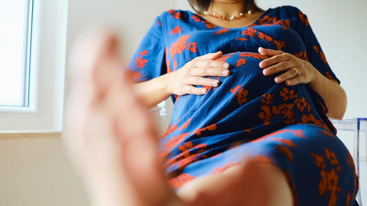 Wassereinlagerungen Schwangerschaft: Schwangere legt Füße hoch