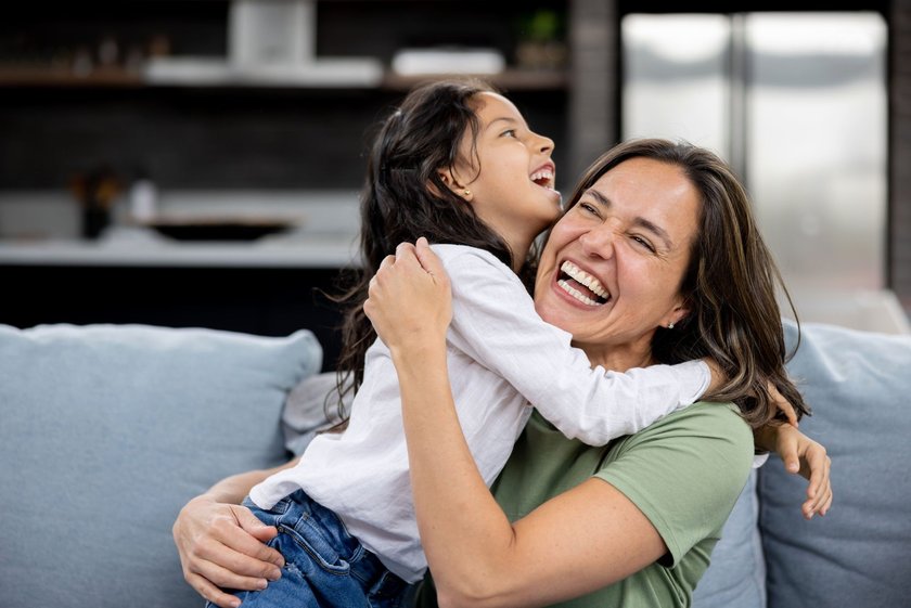 Erziehungsfehler, die deinem Kind nicht schaden: Mama und Kind lachend auf der Couch Erziehungsfehler, die deinem Kind nicht schaden: Mama und Kind lachend auf der Couch