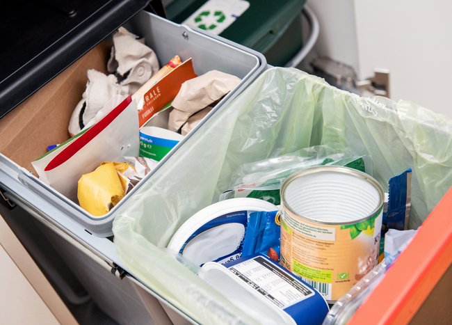 Eine Frau, die einen Müllbeutel entsorgt. Eine Frau, die einen Müllbeutel entsorgt.