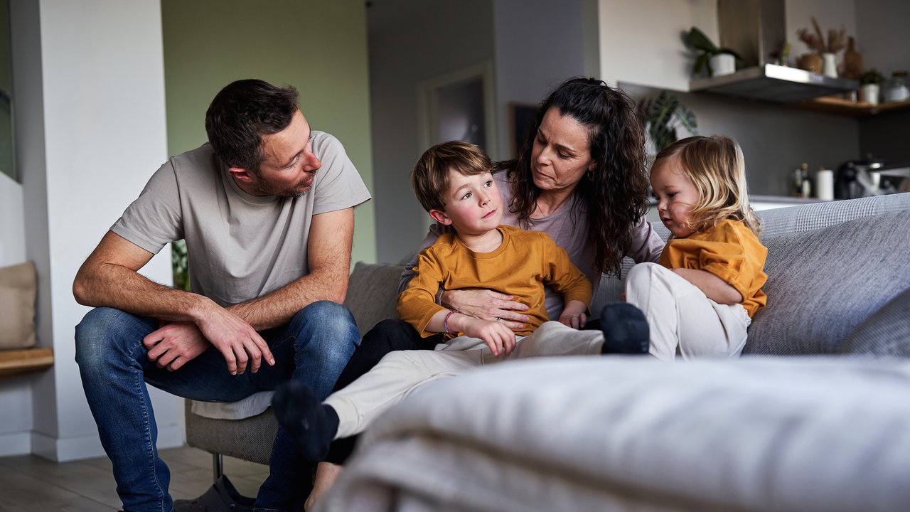 Familie sitzt auf der Couch und bespricht ein Thema. Familie sitzt auf der Couch und bespricht ein Thema.