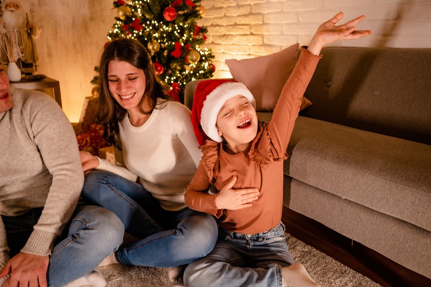 Spiele für die Feiertage für Kinder: Kind singt ein Lied, während die Familie errät, welcher Song es ist