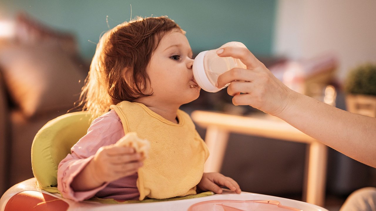 Kleinkind wird mit MIlchflasche gefüttert