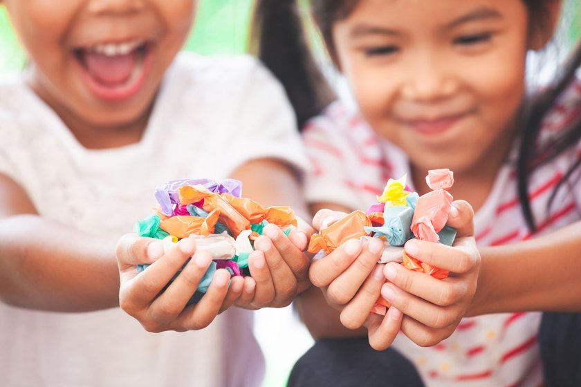 Zwei Kinder halten Bonbons in den Händen