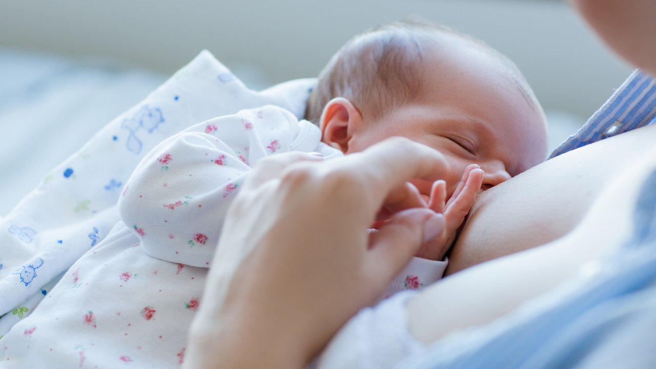 Kolostrum: Mama stillt neugeborenes Baby