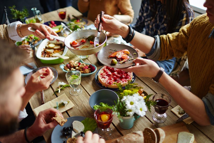 Freunde sitzen an einem Tisch und essen
