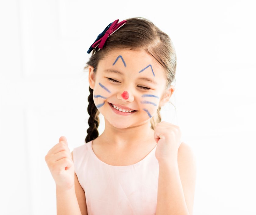 happy little girl with kitty painted face