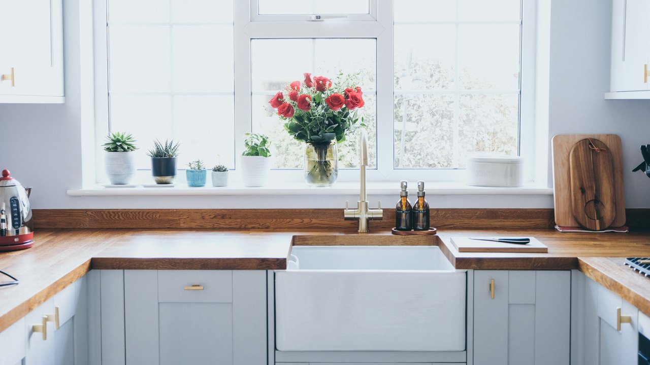 Eine moderne und aufgeräumte Küche mit Blumen auf dem Fensterbrett