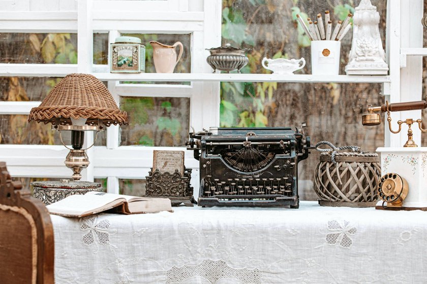 Desk with Vintage typewriter, retro lamp, old phone Working desk with Vintage old fashioned typewriter machine Underwood, antique lamp, retro phone, books next to window in light shabby chic country cottage interior room. Copyright: xZoonar.com/OlenaxYeromenkox 17807337