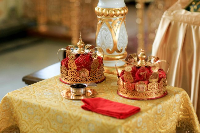 Zwei goldene und rote Kronen auf einem Tisch mit einer goldenen Tischdecke