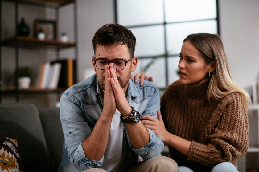 Junger Mann weint vor seiner Freundin.