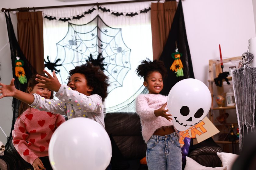 Halloween Kostüme Kinder Sternzeichen: Mädchen spielen mit Halloween-Deko