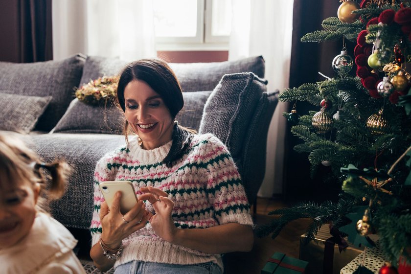 Online shopping: smiling woman buying presents for her loved ones online.