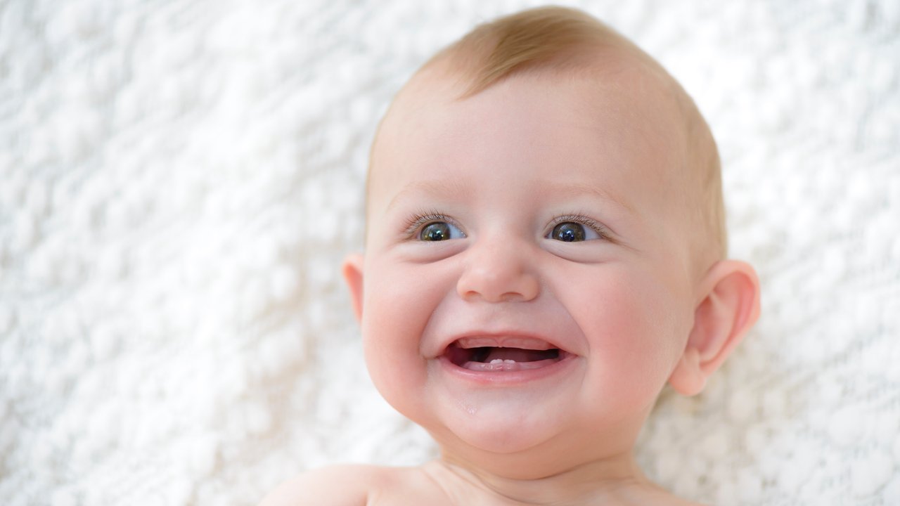 Cute baby laughing and showing his first teeth