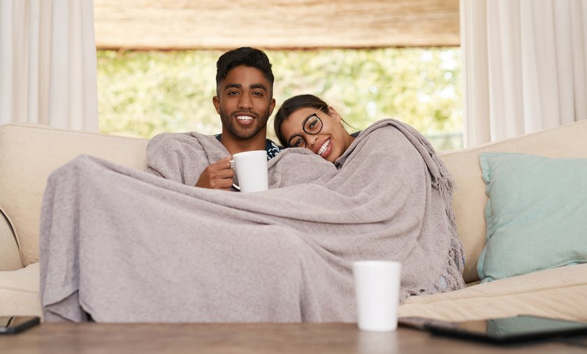Pärchen kuschelt auf dem Sofa