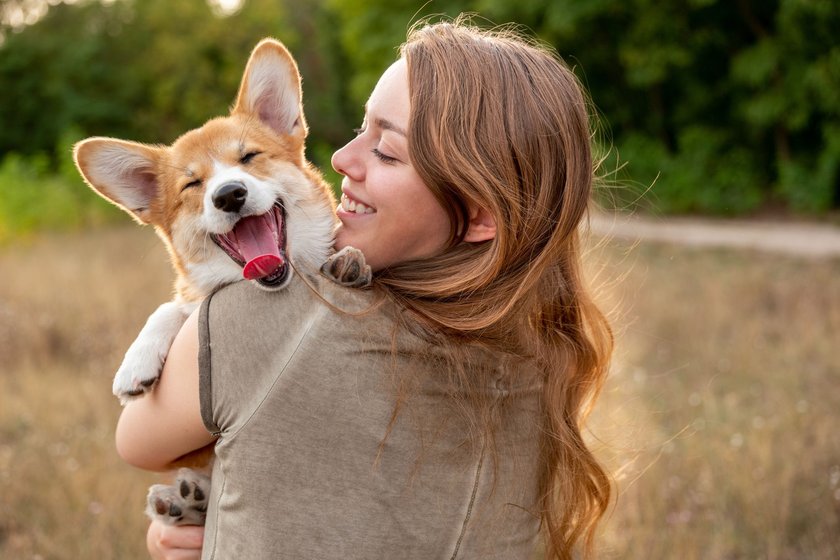 Junge Frau mit einem Corgi Welpen auf dem Arm