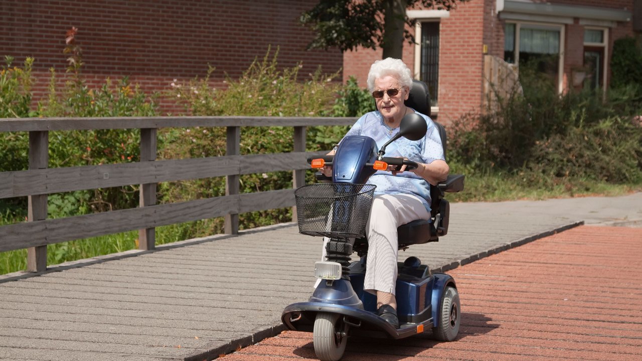 Ältere Dame fährt mit ihrem Elektro-Dreirad für Senioren