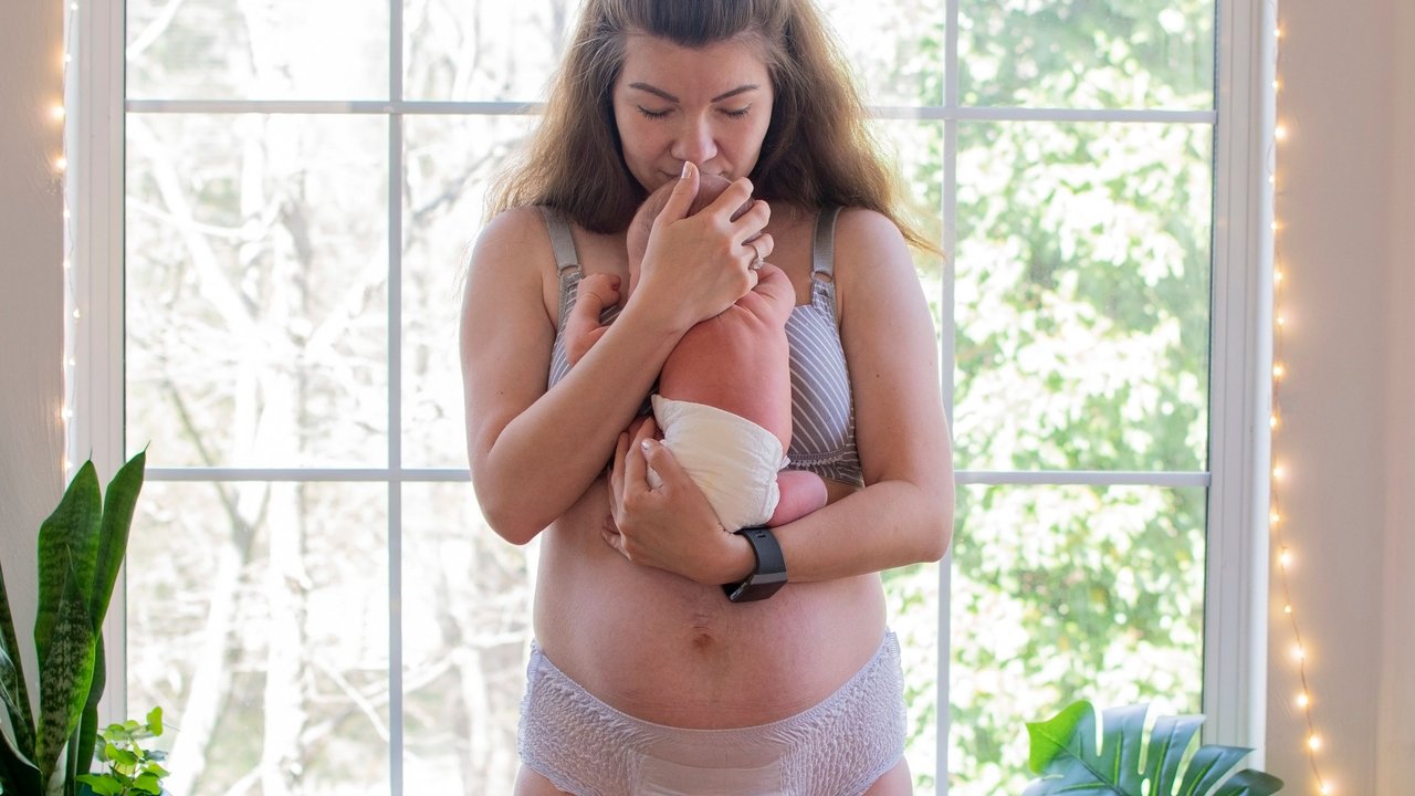 Rektusdiastase: Mama hält Baby vor ihrem Bauch