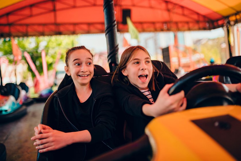 Kindergeburtstag im Freizeitpark: Zwei Mädchen fahren Autoscooter