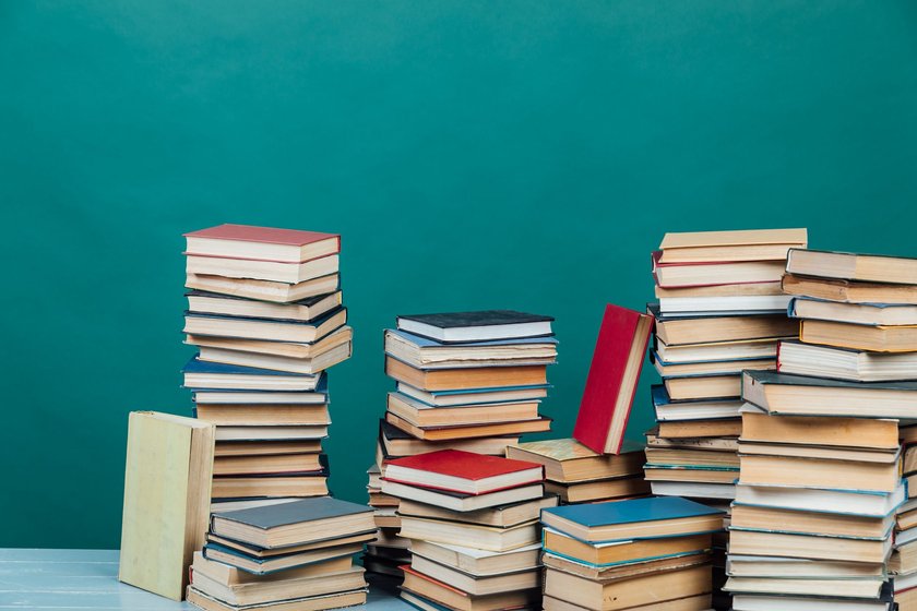 Bücherstapel vor einem türkisfarbenen Hintergrund